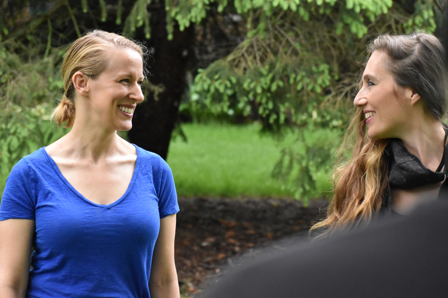 Two women actors smile while doing an activity outdoors
