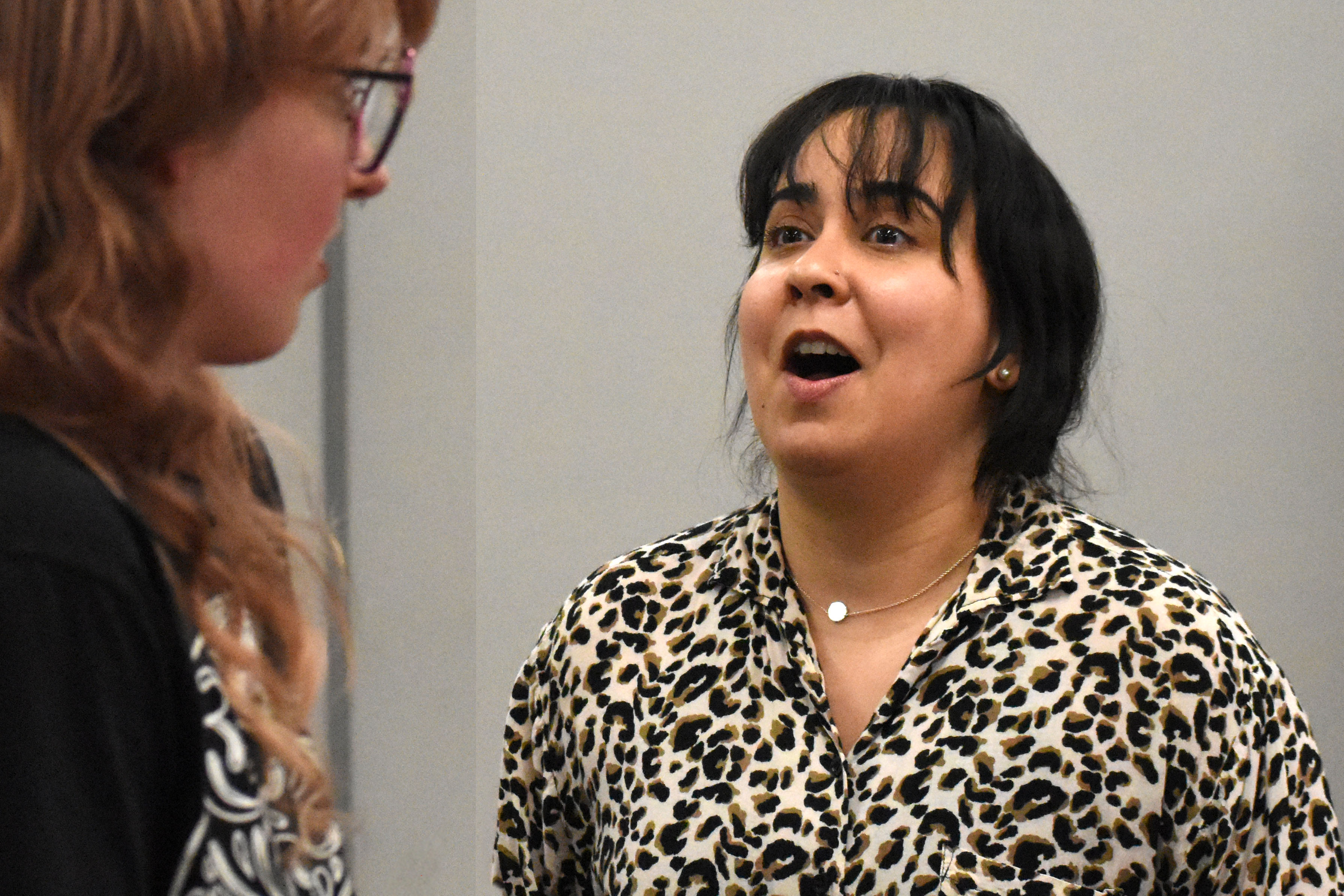 A woman actor looks excitedly at another actor.